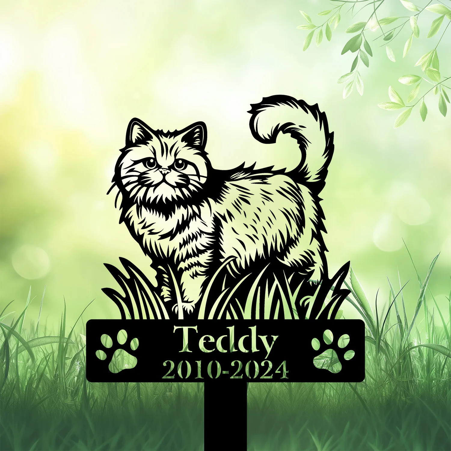Black cat memorial garden stake in grass with paw prints and text Teddy 2010-2024