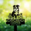 Black garden memorial stake with dog and flowers, reading In Loving Memory Of Cooper 2012-2024, in grass.