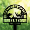 Black yard stake sign reading "Hunting in Heaven Dad 1952-2024," with hunter, deer, and pine silhouettes in grass