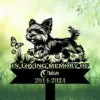 A memorial sign featuring a playful dog with a butterfly and flowers, reading 'In Loving Memory of Orion 2014-2024'.