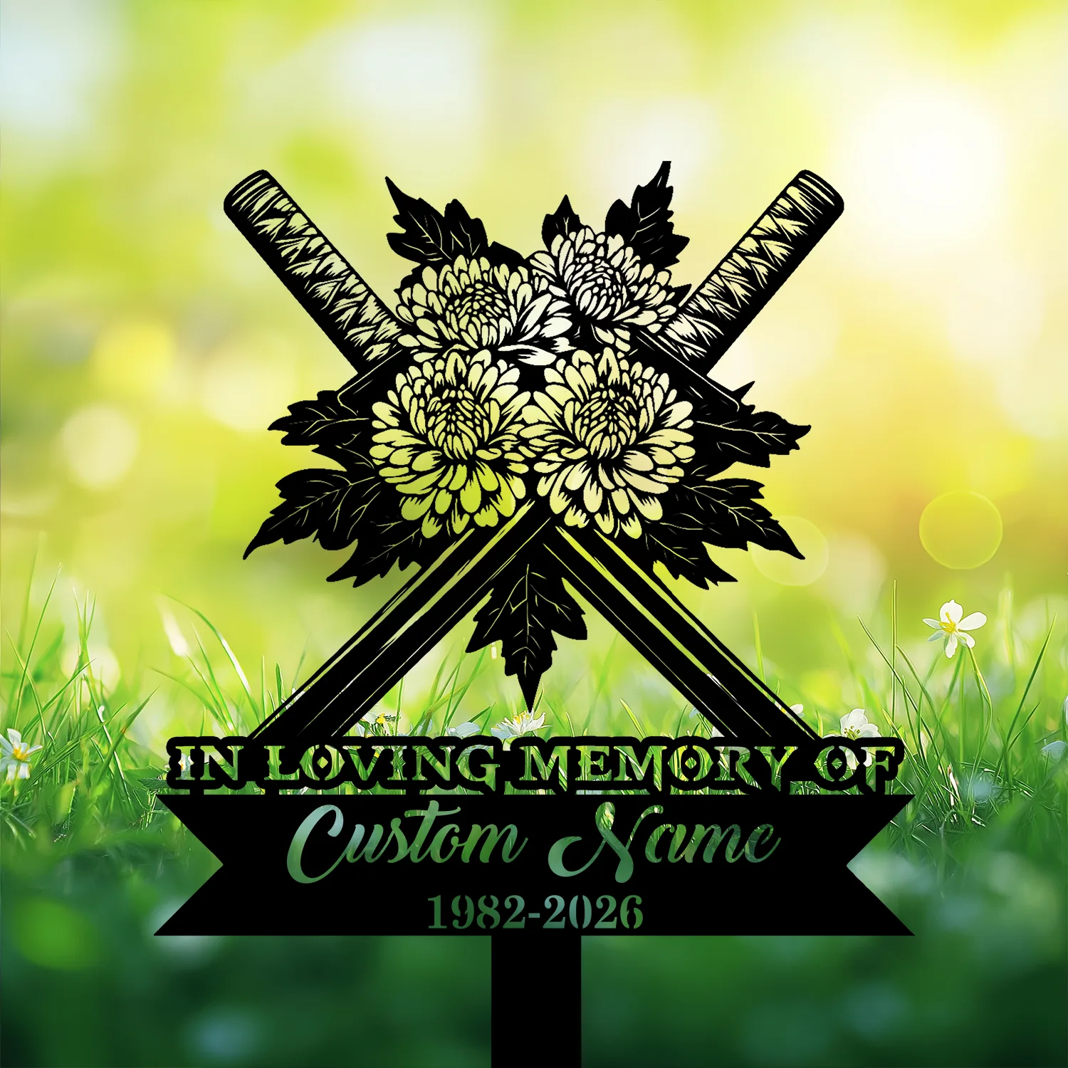 Garden memorial sign with crossed swords and chrysanthemum bouquet above text reading "In Loving Memory" and a customizable name and dates, set against sunlit grass background