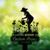 Black silhouette memorial sign of a woman watering flowers with butterflies, 'IN LOVING MEMORY OF' and placeholder 'Custom Name 1987-2026' on a sunny green bokeh background