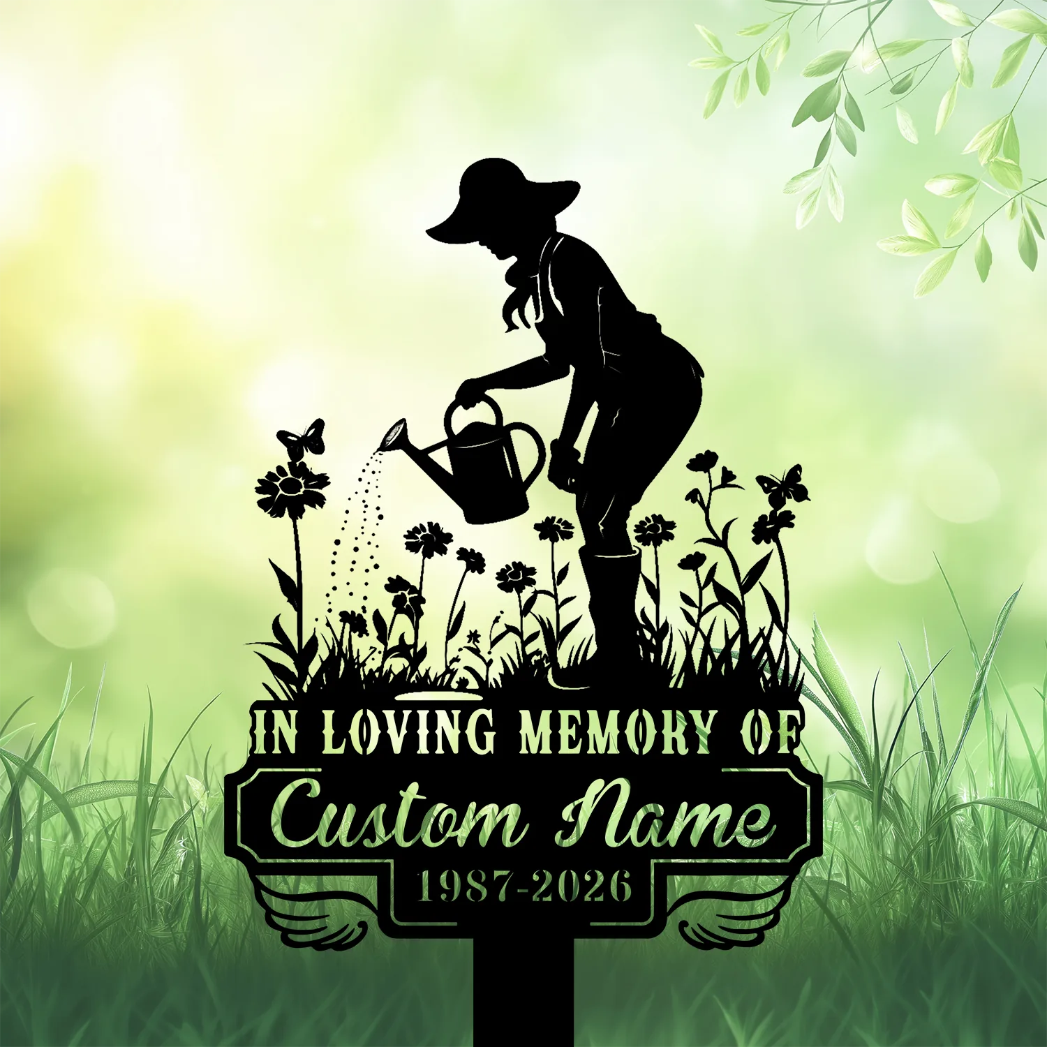 Silhouette memorial garden sign showing a woman watering flowers with a watering can, text reading 'IN LOVING MEMORY OF', 'Custom Name' and dates '1987-2026' on a green blurred background