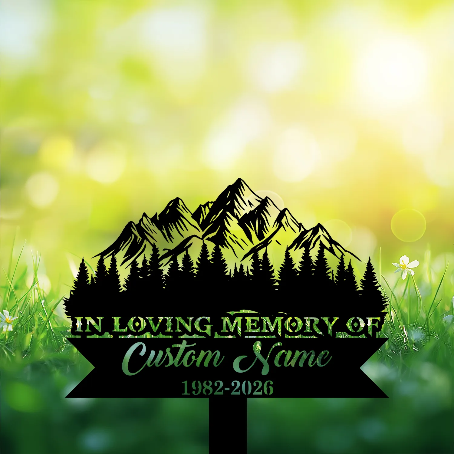 11 Black metal memorial stake with mountain and pine silhouette reading "In Loving Memory of" and placeholder name, grassy blurred background