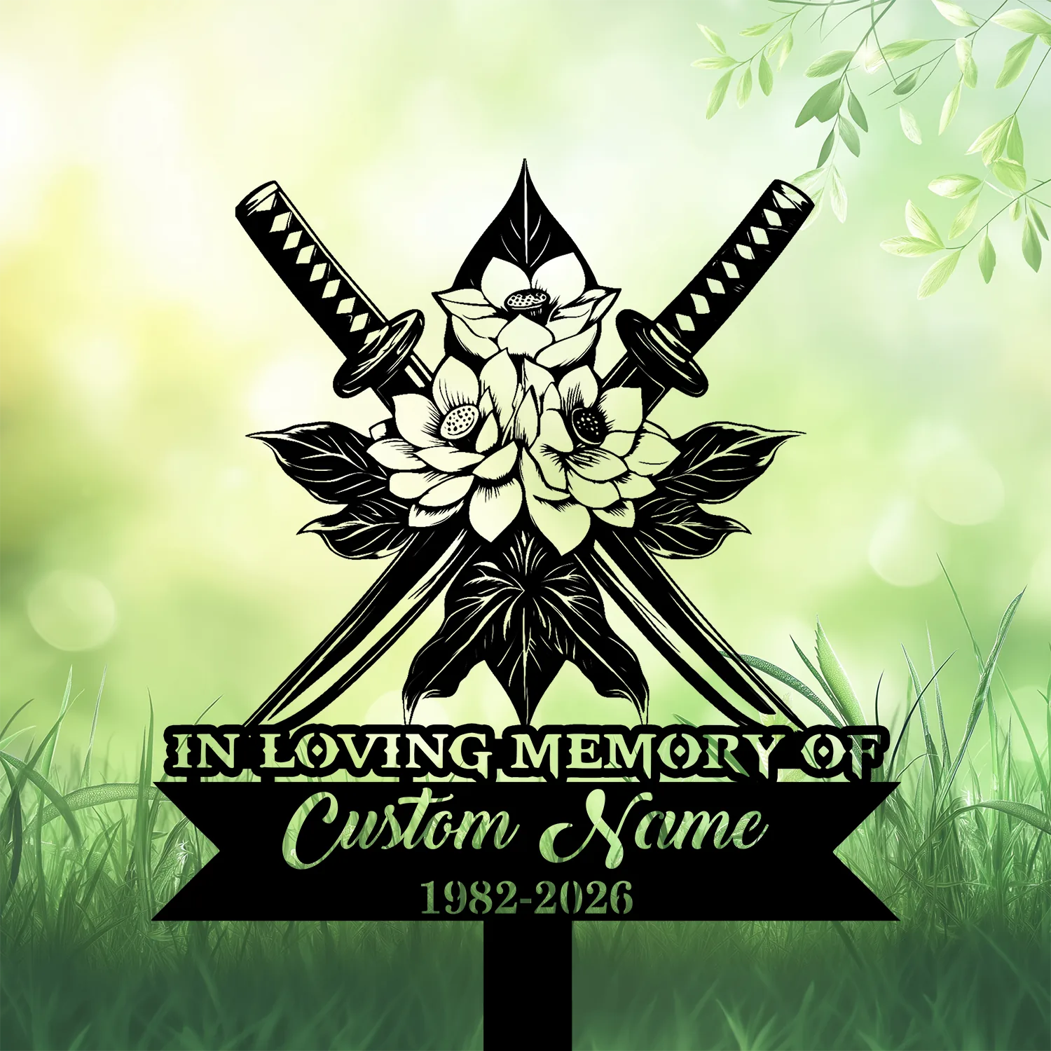 Black silhouette memorial sign with crossed katanas and floral motif above banner reading "IN LOVING MEMORY OF" and placeholder "Custom Name" with dates 1982–2026, against a soft green grassy background