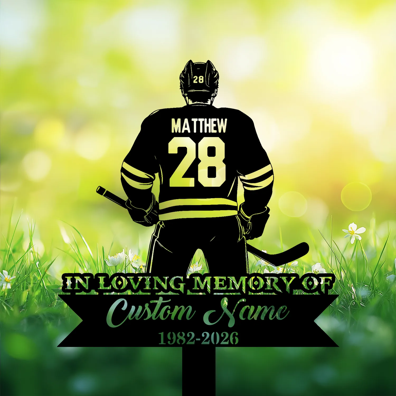 14 Silhouette of a hockey player wearing jersey name "MATTHEW" and number 28 standing over grassy field with daisies and memorial text banner reading "In Loving Memory" and dates 1982-2026