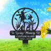 Circular black metal memorial sign with a hunter, dog, reeds and flying ducks, text reading "In Loving Memory Of" with placeholder "CUSTOM NAME" and dates "1950 - 2024", displayed on grassy lawn with blue sky and sunflowers.