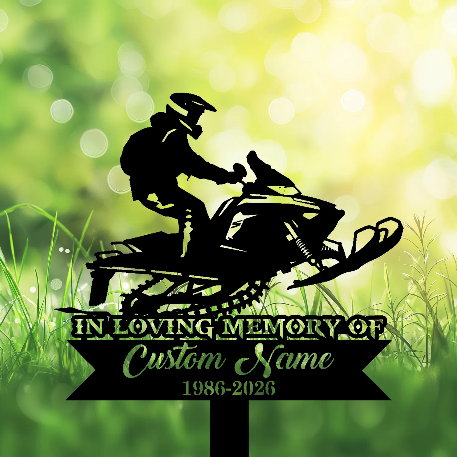 Silhouette of a person riding a snowmobile above text reading "In Loving Memory" and placeholder "Custom Name 1986-2026" against a sunlit green bokeh and grassy background