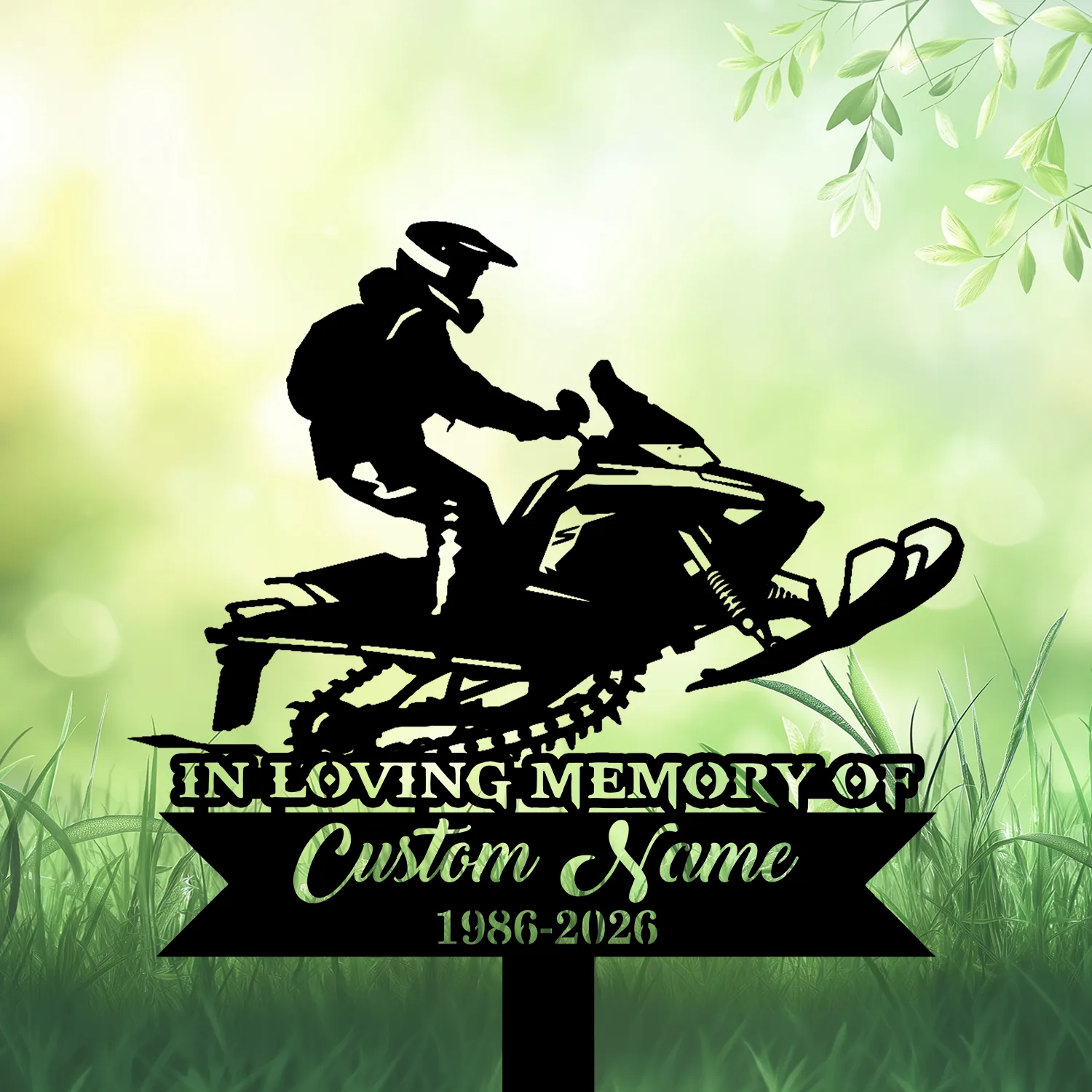 Black silhouette of a person riding a snowmobile above a memorial plaque reading "IN LOVING MEMORY" and "Custom Name 1986-2026" on a soft green leafy background