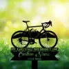 Black silhouette of a road bicycle over a ribbon sign reading "In Loving Memory" and placeholder "Custom Name 1982-2026" against a sunlit grassy background