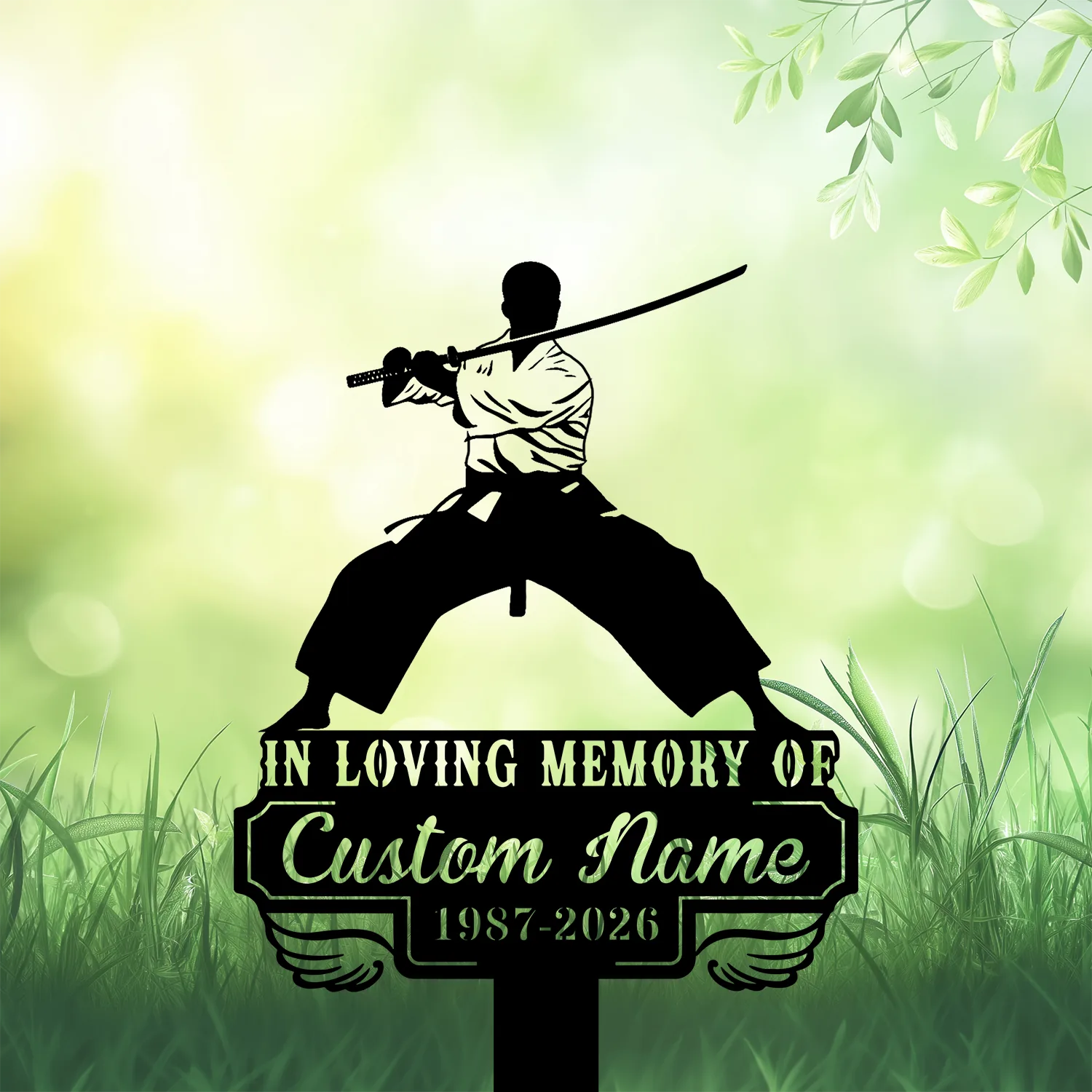 Silhouette of a samurai in a wide stance holding a katana above a memorial sign reading 'IN LOVING MEMORY OF' and 'Custom Name 1987-2026' against a soft green grassy background