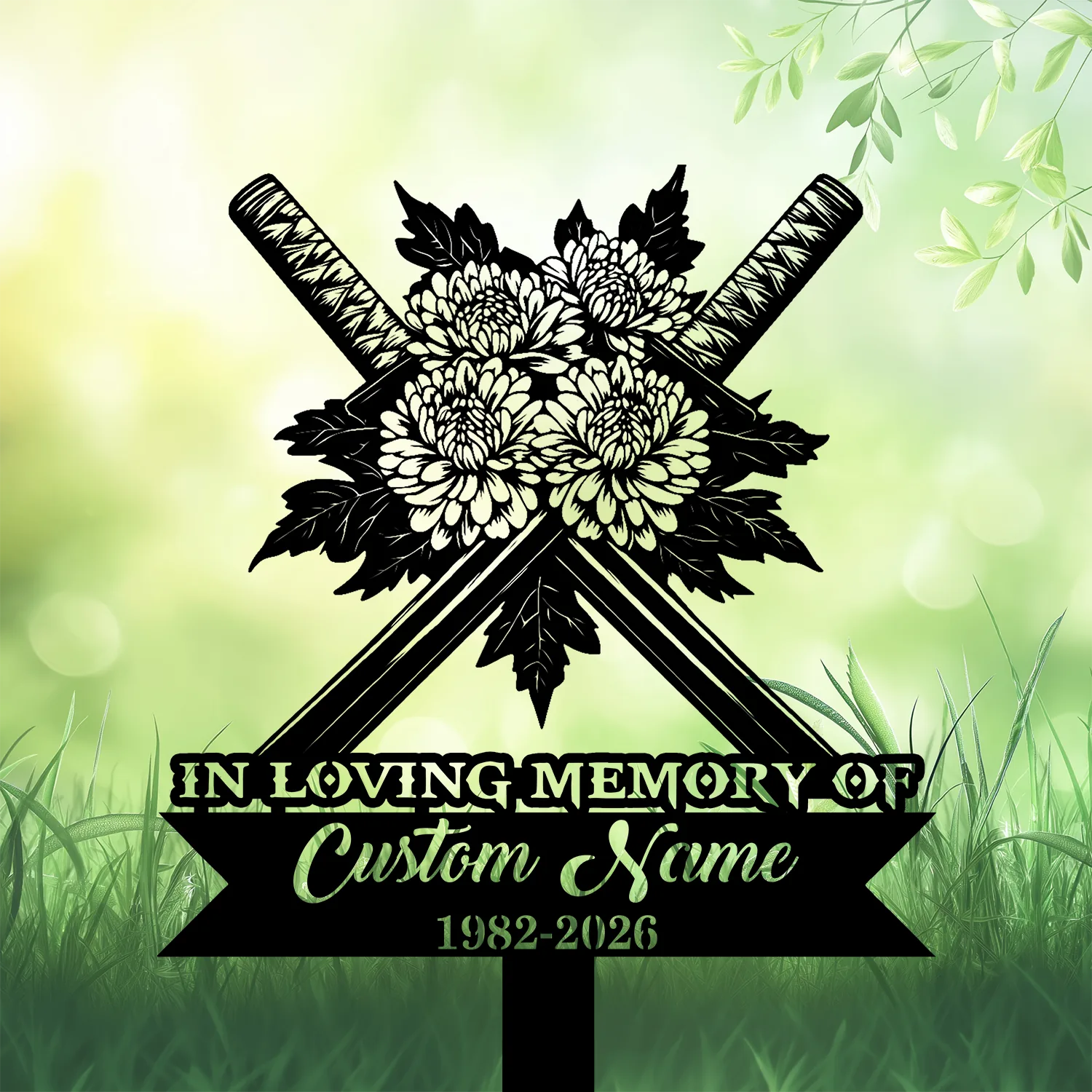Black silhouette memorial sign with crossed swords and chrysanthemum flowers above a ribbon reading “In Loving Memory of” and placeholder text “Custom Name 1982-2026” on a green grassy background