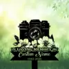 Black silhouette memorial sign with a vintage camera above flowers, ribbon reading "IN LOVING MEMORY OF" and placeholder "Custom Name 1982-2026" on green grassy background