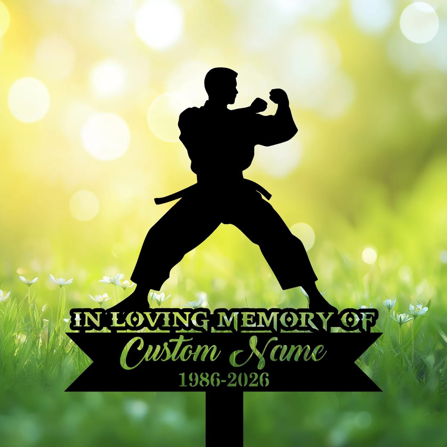 Silhouette of a martial artist in a fighting stance above a memorial sign reading "In Loving Memory of Custom Name 1986-2026" against a sunny grassy bokeh background