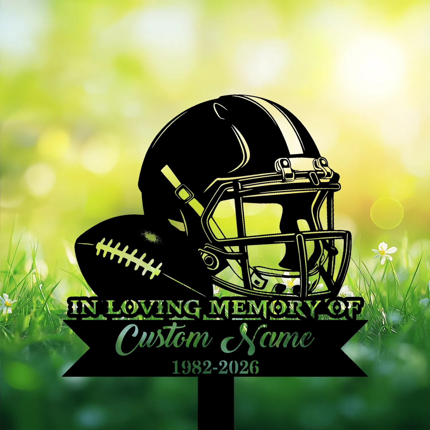 Black silhouette memorial sign with a football and helmet reading "In Loving Memory of" and placeholder "Custom Name 1982-2026" against sunlit grass background