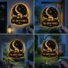 Round illuminated hanging sign with raven on a skull under a crescent moon and stars, personalized text 'THE SMITH FAMILY', shown on porches and garden hooks at night