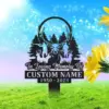 202 Memorial yard sign with deer silhouettes, pine trees and antlers reading "In Loving Memory Of" and placeholder "CUSTOM NAME 1950-2023" on a grassy lawn with sunflowers and blue sky.