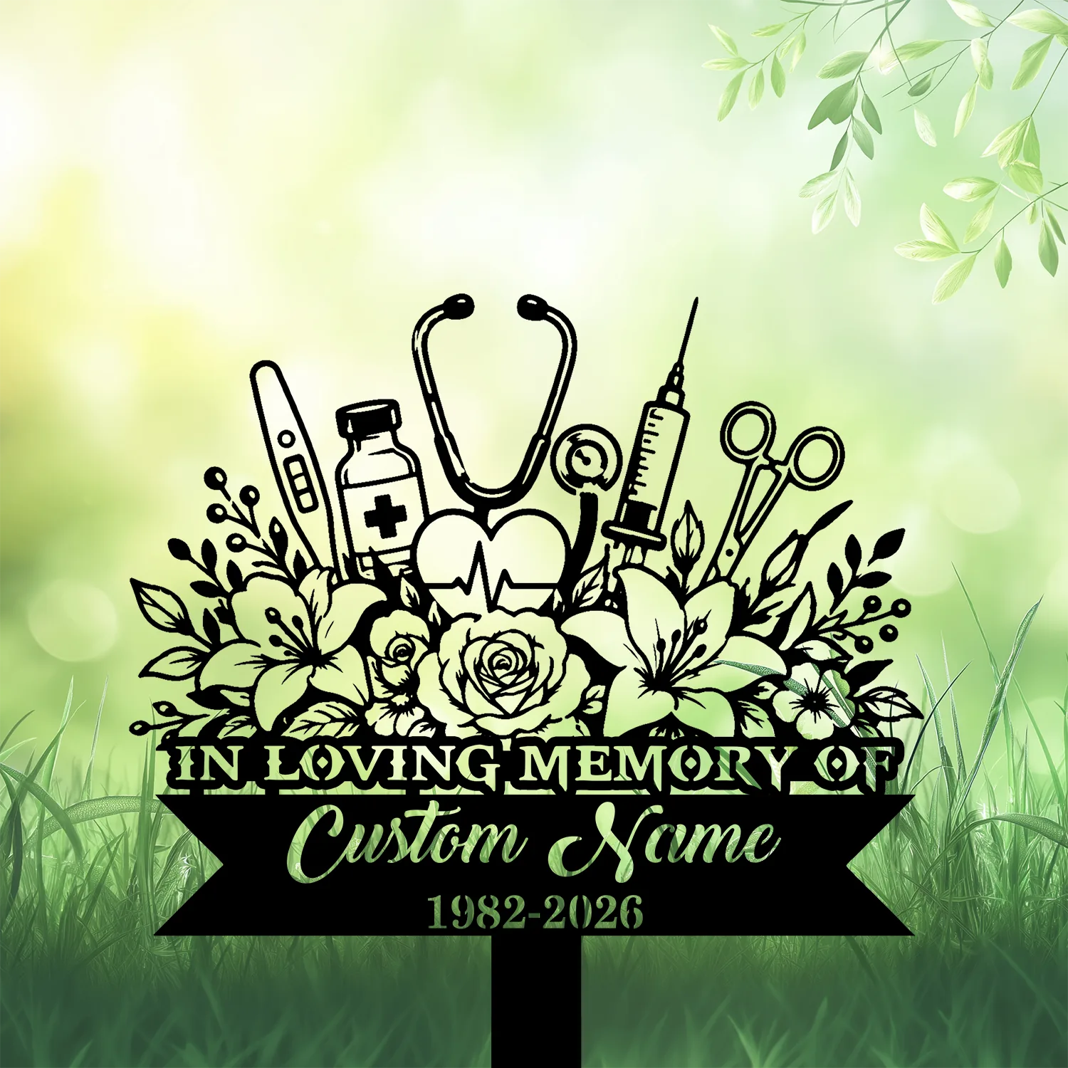 Black memorial sign with floral bouquet and medical icons (stethoscope, syringe, vial, thermometer) reading "In Loving Memory" and placeholder "Custom Name 1982-2026" against a soft green garden background
