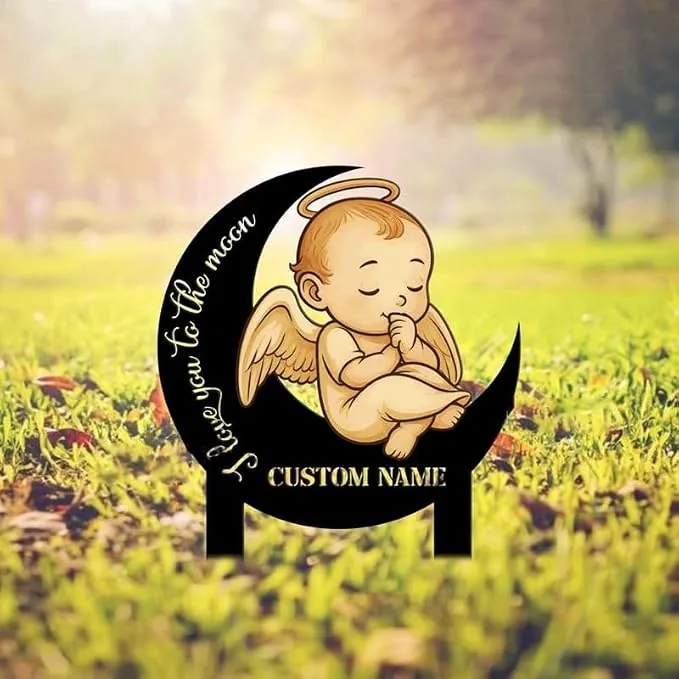 Cute sleeping baby angel with halo and wings sitting on a black crescent moon sign in a grassy outdoor setting, text reading "I love you to the moon" and placeholder "CUSTOM NAME"