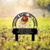 Outdoor memorial garden stake with a daisy and ladybug illustration, circular frame reading 'CUSTOM NAME 1973-2025' and a sentimental goodbye message plaque
