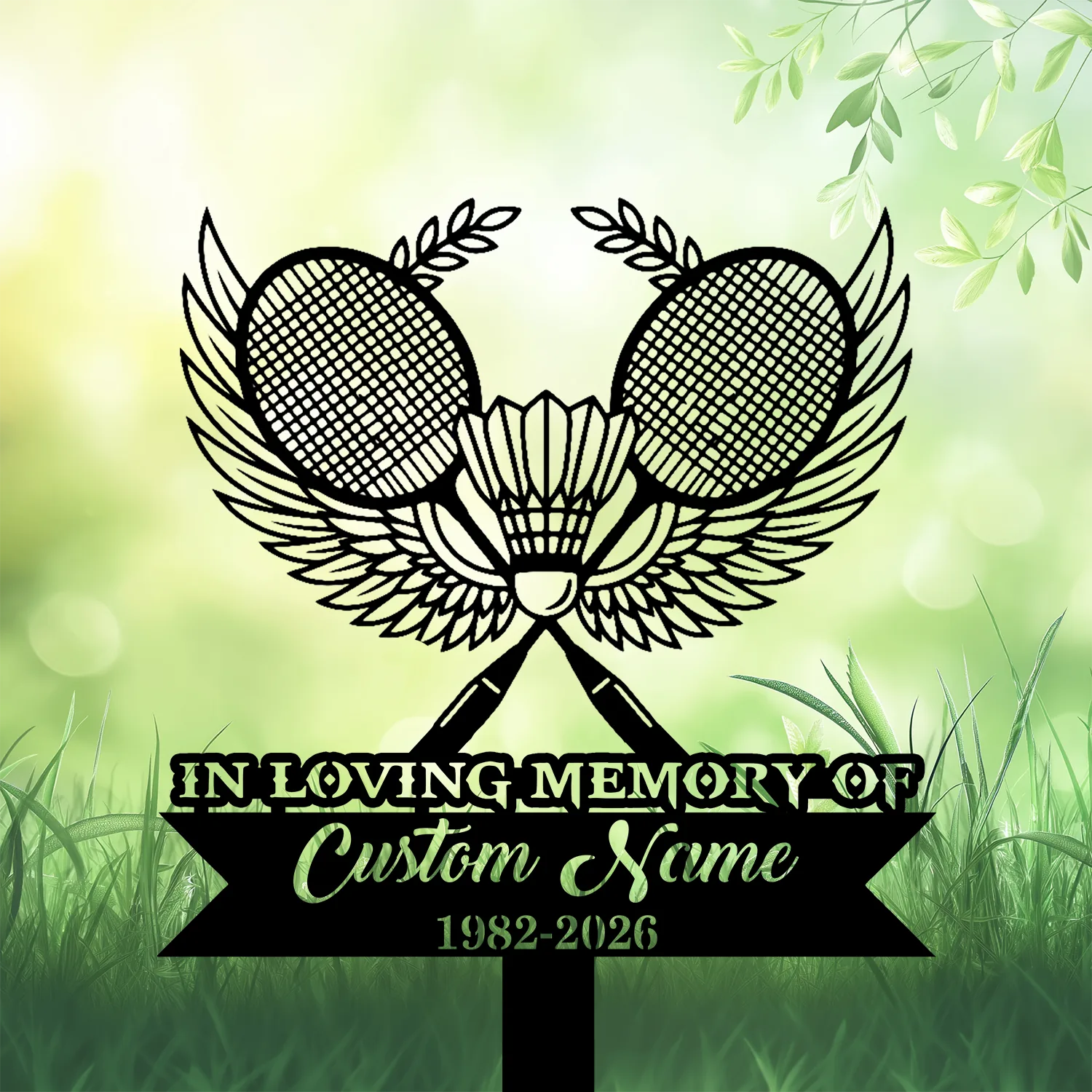 3b-2 Black memorial sign with crossed badminton rackets, shuttlecock and wings over a green grassy, leafy background reading “In Loving Memory” and placeholder "Custom Name" with dates 1982-2026