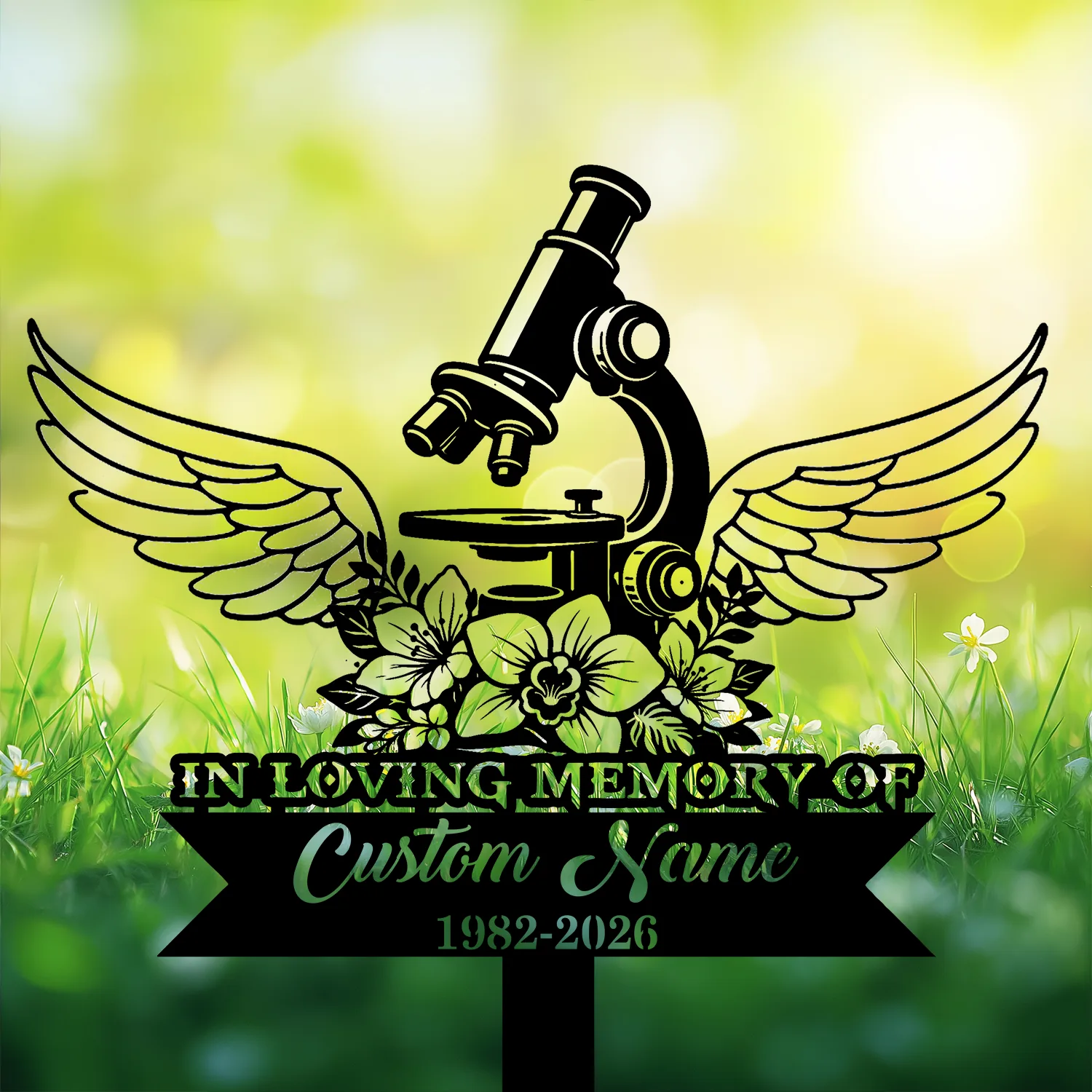 Black silhouette memorial sign showing a microscope with wings and flowers, text reading "IN LOVING MEMORY OF" and placeholder "Custom Name 1982-2026" against a sunlit grassy background