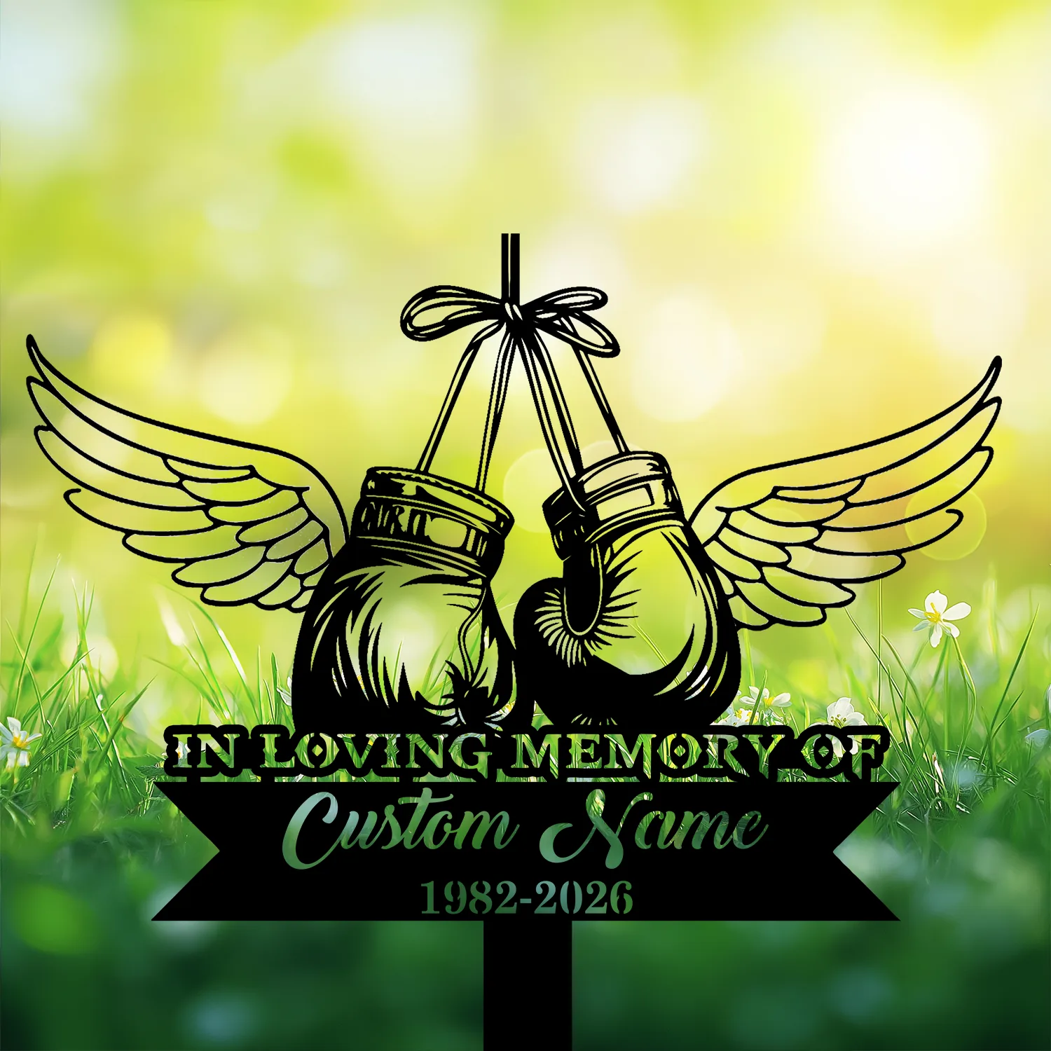 5-3 Memorial sign with winged boxing gloves hanging by a ribbon over grass and flowers, text reading "IN LOVING MEMORY OF" and placeholder "Custom Name 1982-2026"