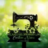 Black silhouette of a vintage sewing machine with floral accents over green grass and bokeh background, text reading "In Loving Memory of Custom Name 1982-2026"
