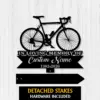 6a-3 Black metal memorial sign with a bicycle silhouette, text reading "IN LOVING MEMORY OF" and placeholder "Custom Name" with dates 1982-2026, shown on a white wood background