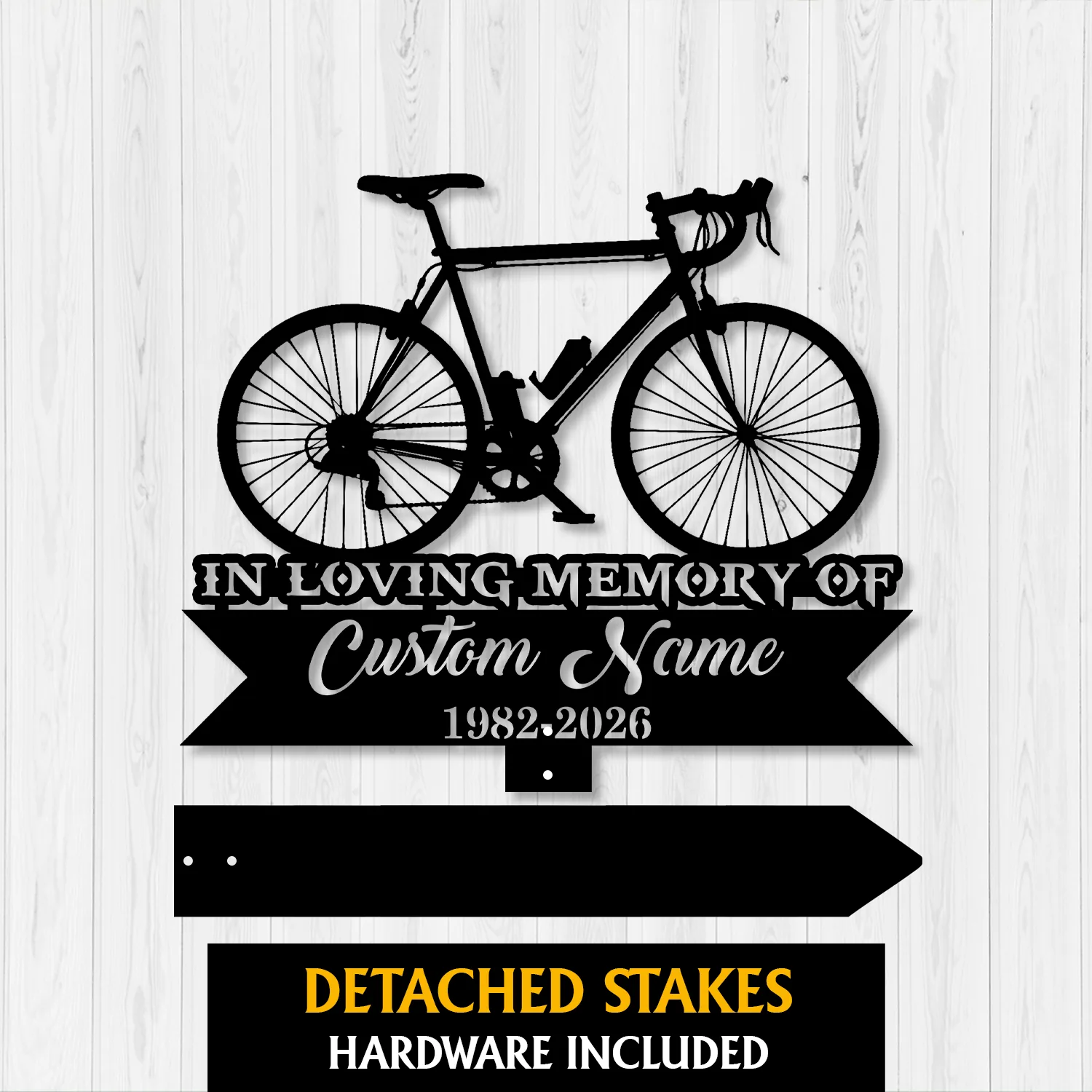 6a-3 Black metal memorial sign with a bicycle silhouette, text reading "IN LOVING MEMORY OF" and placeholder "Custom Name" with dates 1982-2026, shown on a white wood background