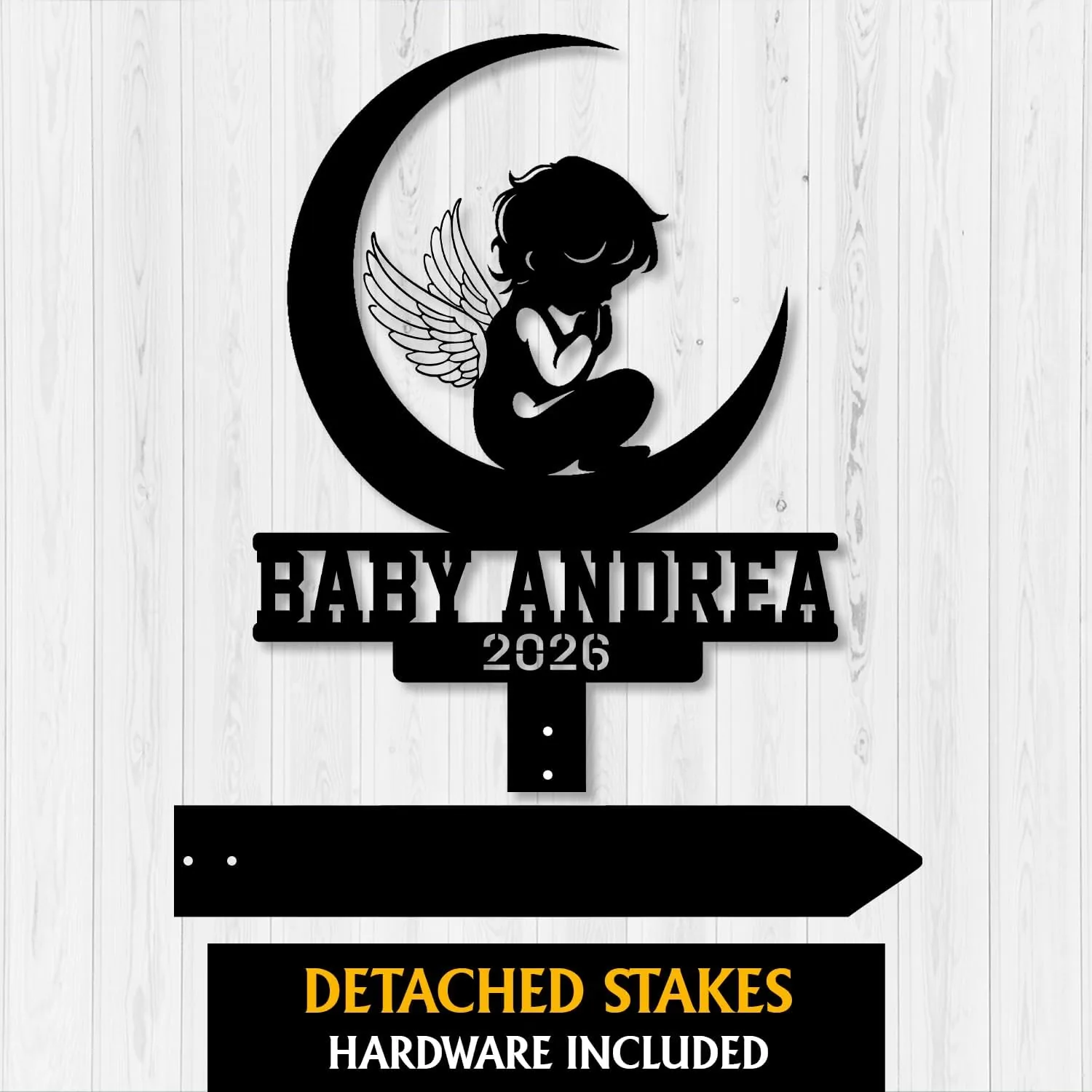 Black silhouette nursery sign showing a winged baby sitting on a crescent moon with text "BABY ANDREA" and year "2026" on a light wood background