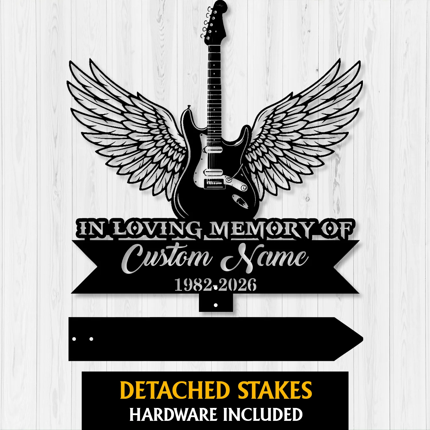 Black silhouette memorial sign of an electric guitar with angel wings over text reading "In Loving Memory of" and placeholder "Custom Name 1982-2026" on a light wood background.