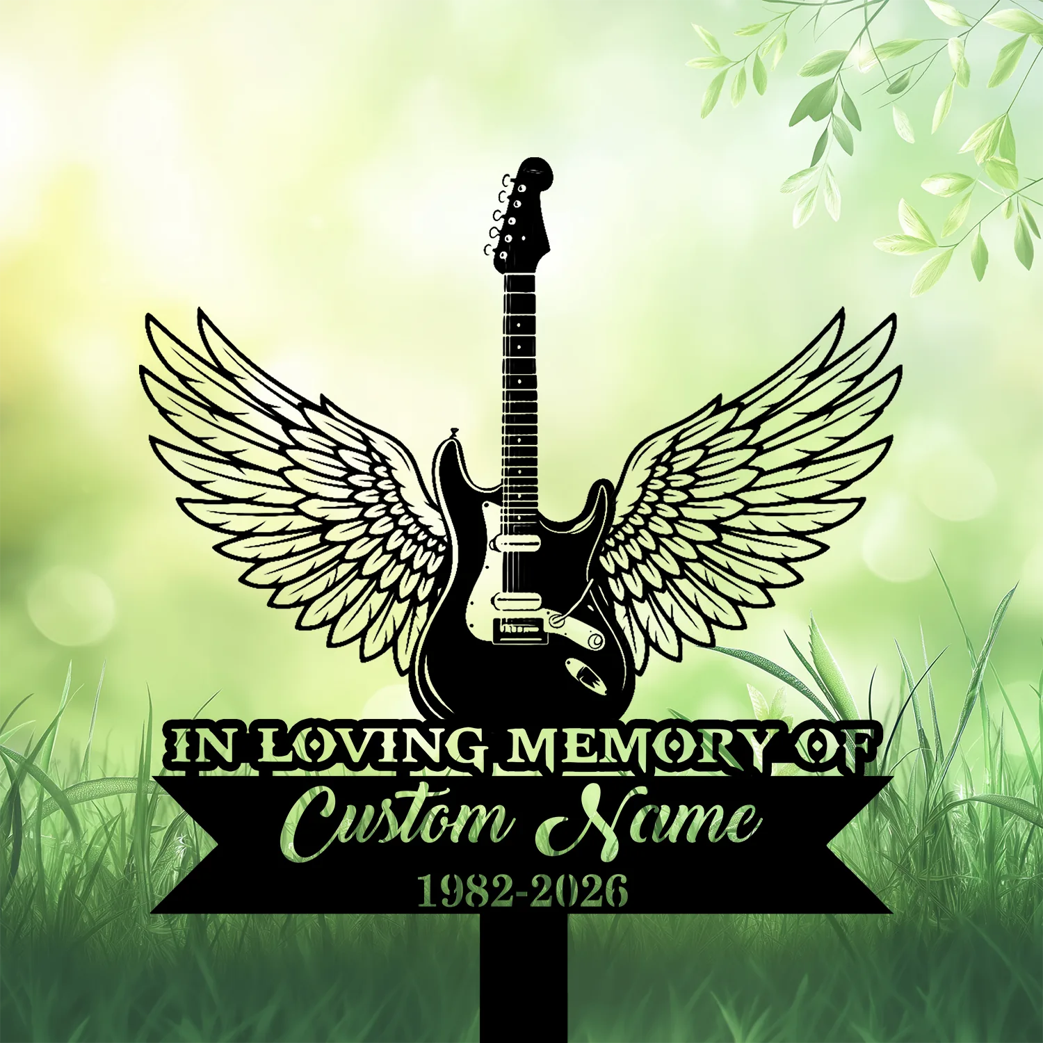 Black electric guitar with angel wings on a green bokeh background above grass, memorial sign reading "IN LOVING MEMORY", placeholder "Custom Name" and dates 1982-2026
