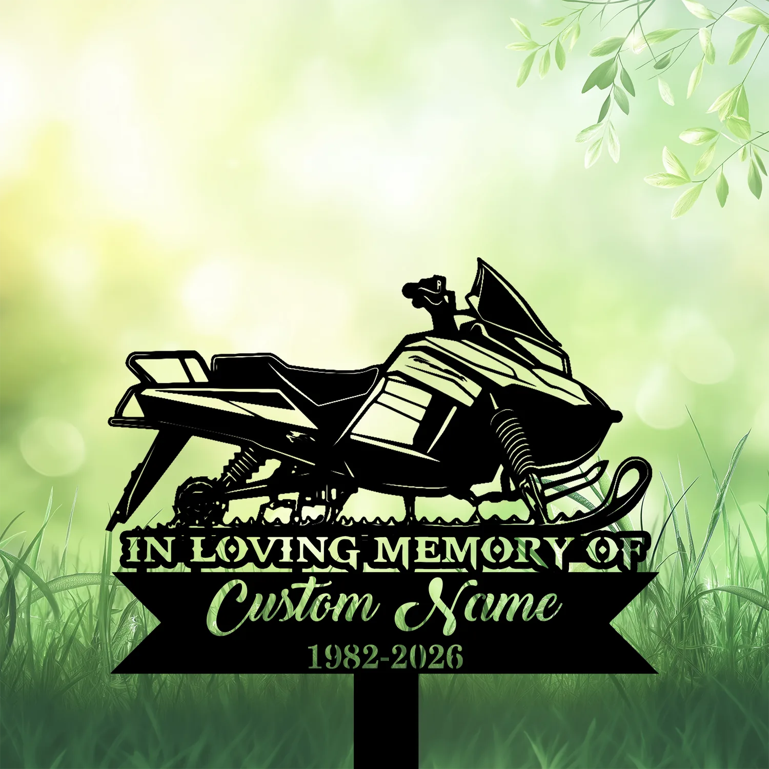 8b-3 Black silhouette memorial yard sign of a snowmobile with text "In Loving Memory of" and customizable name and years against a green grassy bokeh background
