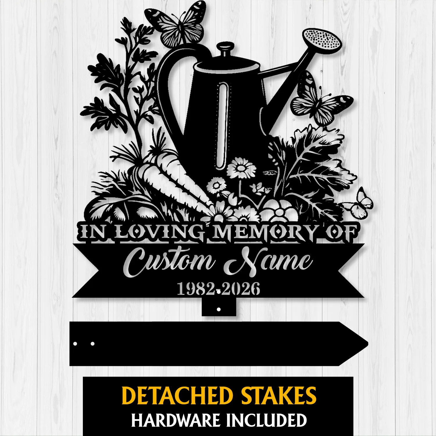 9a-2 Black metal garden memorial sign with watering can, flowers, carrots and butterflies, text reading "In Loving Memory of Custom Name 1982-2026" on a light wood background
