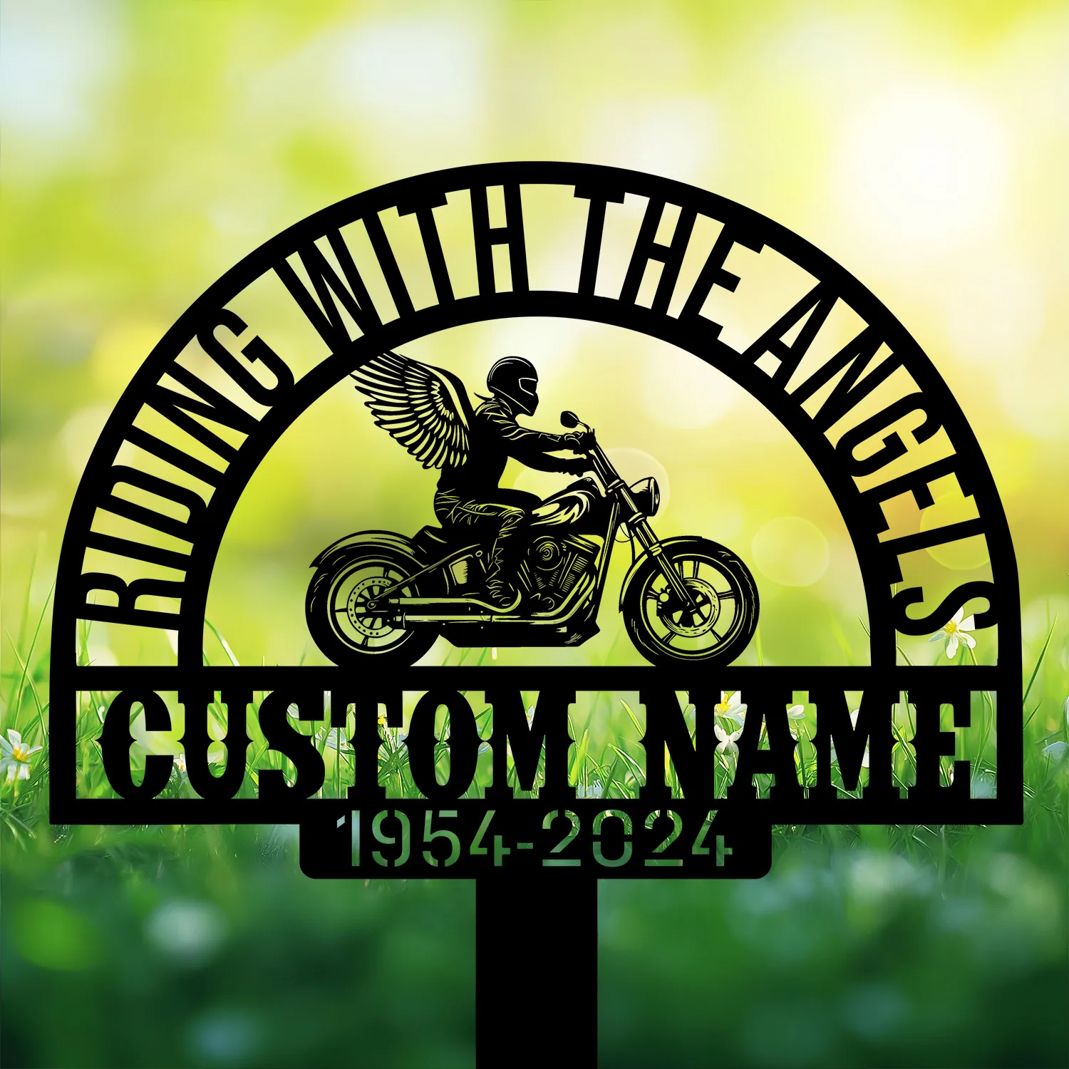 Angel-Biker-1 Black metal memorial sign showing a winged motorcycle rider silhouette under arched text 'RIDING WITH THE ANGELS' and a customizable name with dates '1954-2024' against a sunlit grassy background