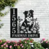 Black metal address sign mounted on white brick wall showing numbers 1565 and text FAIRWAY DRIVE with cutout dog, flowers and butterflies, pink flowers below