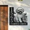 Bichon-Frise-Sitting-with-Butterfly-1-2 Black metal house sign with vertical address numbers 1565 and text 'FAIRWAY DRIVE' beside a wooden door, featuring a happy fluffy dog, daisies and butterflies on a white wall