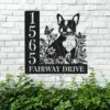 Boston-Terrier-Sitting-with-Butterfly-3 Black metal house sign on a white brick wall showing numbers 1565 and the text FAIRWAY DRIVE with a dog silhouette surrounded by flowers and butterflies above green shrubs