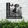 Brittany-Spaniel-Sitting-with-Butterfly-3 Black metal house sign mounted on a white brick wall showing address 1565 and the text FAIRWAY DRIVE beside a sitting dog with flowers and butterflies, greenery below