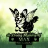 Black silhouette memorial sign of a winged corgi jumping with text “In Loving Memory Of MAX 2016-2024” against a soft green grassy background