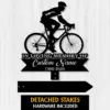 Cyclist-2 Black metal memorial sign showing a cyclist silhouette above text "In Loving Memory of" and customizable name with years 1986-2026 on a light wood background
