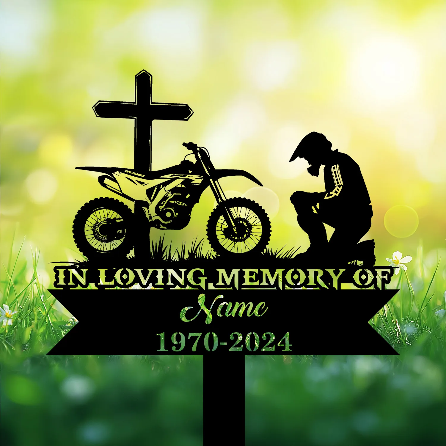 Dirtbike-Racer-Kneeling-at-Cross-1 Silhouette memorial sign with cross, dirt bike, kneeling rider, text reading "IN LOVING MEMORY OF" and placeholder name and years against a sunny green bokeh background