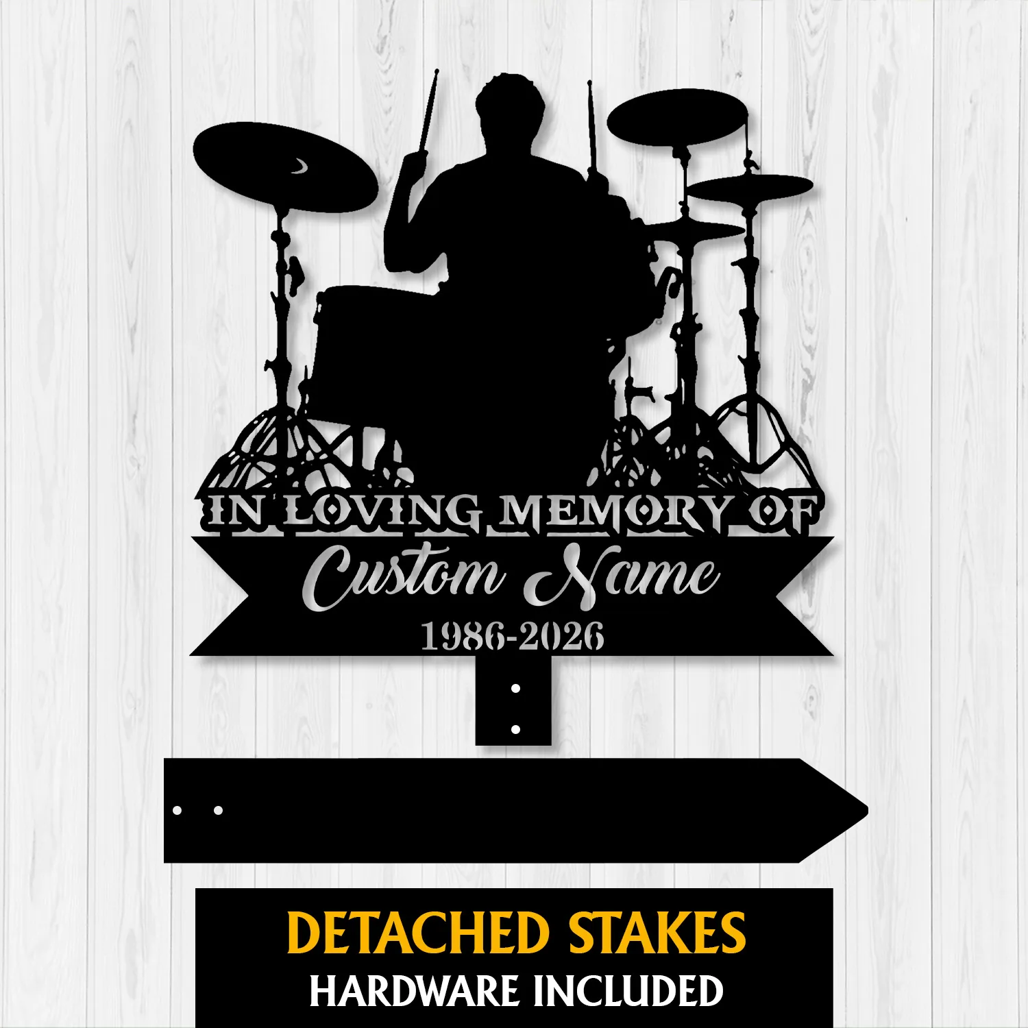 Black silhouette metal memorial sign of a drummer at a drum kit with text "In Loving Memory of Custom Name 1986-2026" shown on a light wood background, detached stakes pictured below.