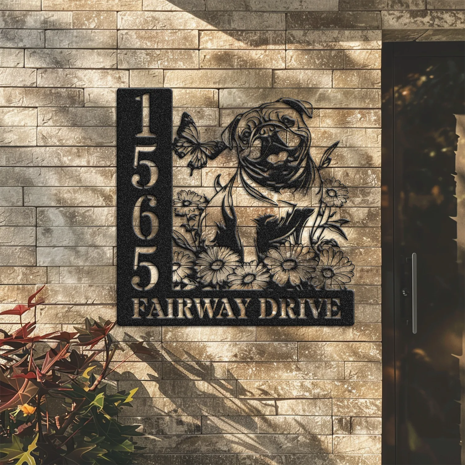 English-Bulldog-Sitting-with-Butterfly-2 Black metal house sign mounted on a brick wall showing numbers 1565, the text "FAIRWAY DRIVE," and a decorative pug with flowers and a butterfly