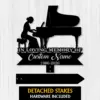 Black silhouette memorial sign showing a woman playing a grand piano with text 'In Loving Memory Of', placeholder 'Custom Name' and years '1986-2026' on a light wood background