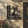 French-Bulldog-Sitting-with-Butterfly-1-1 Black metal house sign on a brick wall showing numbers 1565, a sitting French bulldog with flowers and butterflies, and the text 'FAIRWAY DRIVE'