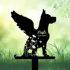 Black dog silhouette memorial stake with wings and floral cutouts, text “Layla 2015-2025” against a soft green garden background