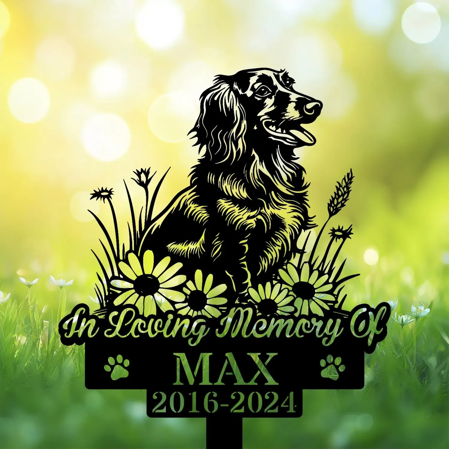 Longhair-Dachshund-2 Black silhouette memorial sign of a happy dog sitting among daisies reading "In Loving Memory Of MAX 2016-2024" on a sunlit green bokeh background