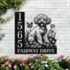 Black metal house sign mounted on a white brick wall with address numbers 1565 and text 'FAIRWAY DRIVE' beside a floral poodle silhouette, surrounded by pink flowers and green vines.